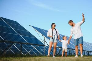 contento familia cerca solar paneles alternativa energía fuente foto