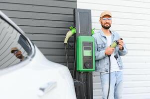 un hombre cargos un eléctrico coche foto