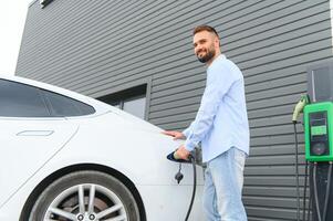 un hombre cargos un eléctrico coche foto