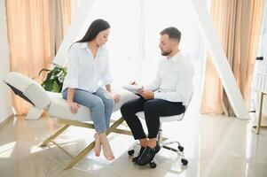 Male doctor and female patient at therapy session photo