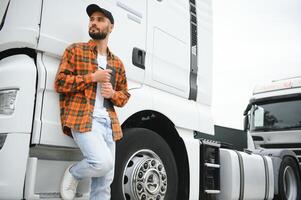 retrato de joven barbado camionero en pie por su camión vehículo. transporte servicio. camión conductor trabajo foto
