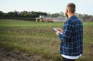 Farmer working on field in modern agriculture - tractor background. photo