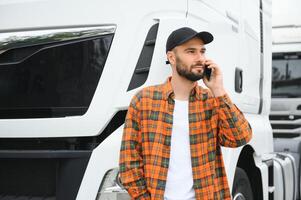 Man trucker talking on the phone by his white truck photo