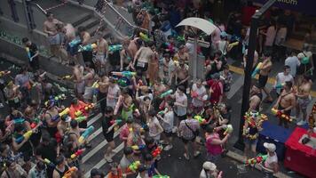 Bangkok, Thailand, April 13, 2024 - - thailändisch Neu Jahr oder Songkran Festival Tausende von Menschen versammeln beim Silom Straße Wasser Kampf Spritzen mit Wasser Gewehr video