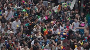 Bangkok, thailand, april 13, 2024 - thai ny år eller songkran festival tusentals av människor samla på silom väg vatten bekämpa stänk med vatten pistol video