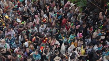 Bangkok, thailand, april 13, 2024 - thai ny år eller songkran festival tusentals av människor samla på silom väg vatten bekämpa stänk med vatten pistol video