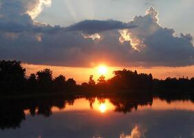 Spectacular sunset over, orange sun rising up over the horizon photo