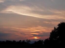 Spectacular sunset over, orange sun rising up over the horizon photo