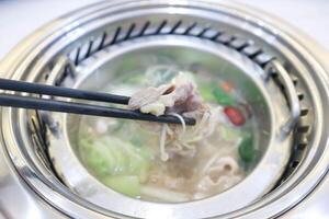 eating Sukiyaki ,suki or shabu pot photo