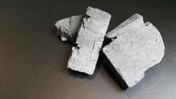 Natural wood charcoal traditional charcoal or hard wood charcoal on wooden table top view. photo