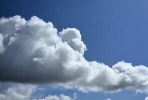 White fluffy cumulus clouds background. Summer clouds in the blue sky photo