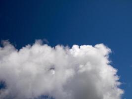 White cumulus clouds in the deep blue summer sky. Fluffy clouds background photo