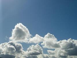 White fluffy cumulus clouds in the summer sky, natural clouds background photo