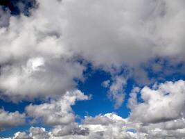 White cumulus clouds in the deep blue summer sky. Fluffy clouds background photo