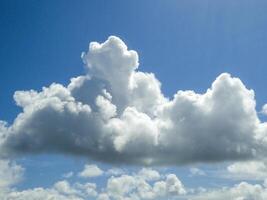 White fluffy cumulus clouds background. Summer clouds in the blue sky photo