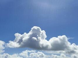 White fluffy cumulus clouds background. Summer clouds in the blue sky photo