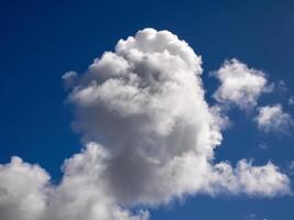 White cumulus clouds in the deep blue summer sky. Fluffy clouds background photo