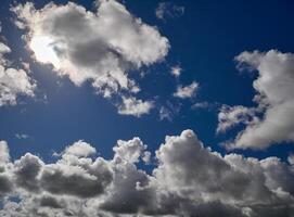 White cumulus clouds in the deep blue summer sky. Fluffy clouds background photo