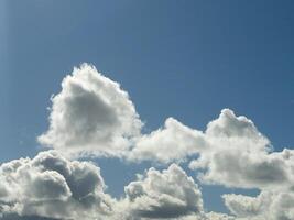 White fluffy cumulus clouds in the summer sky, natural clouds background photo