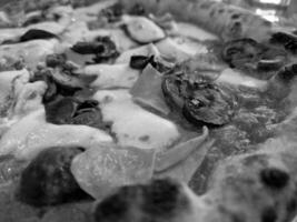 Tasty pizza close view background. Black and white pizza photo