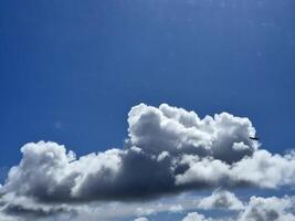 White fluffy cumulus clouds background. Summer clouds in the blue sky photo
