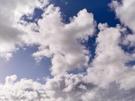 White fluffy cumulus clouds in the summer sky, natural clouds background photo