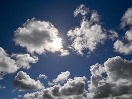 White cumulus clouds in the deep blue summer sky. Fluffy clouds background photo