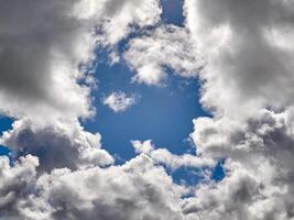 White cumulus clouds in the deep blue summer sky. Fluffy clouds background photo