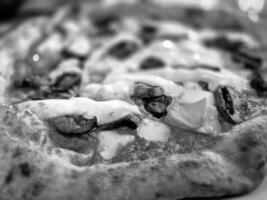 Tasty pizza close view background. Black and white pizza photo