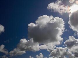 White cumulus clouds in the deep blue summer sky. Fluffy clouds background photo