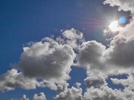 White cumulus clouds in the deep blue summer sky. Fluffy clouds background photo