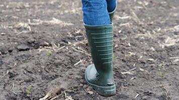 Farmer worker goes home after harvesting end of the working day feet in rubber boots agriculture video