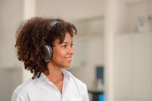 negro mujer escuchando a música o alguna cosa interesante y disfrutando eso escucha y aprender foto