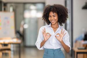portrait of pretty smiling black woman showing ok sign, attarctive cheerful with two hands OK symbol photo