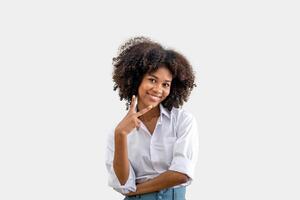 A young black woman smiling holds up two fingers. isolated on a white background. two sign , Positive human emotion. photo