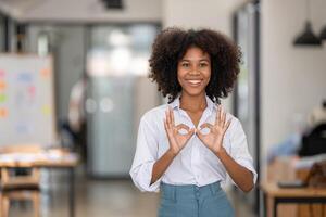 portrait of pretty smiling black woman showing ok sign, attarctive cheerful with two hands OK symbol photo