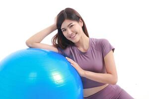 hermosa asiático mujer disfrutando ejercicio. ella estaba propensión en un azul yoga pelota. blanco antecedentes. peso pérdida ejercicio concepto. salud cuidado foto