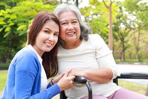 Elderly mother and daughter smiling happily in the park in the morning. Family concept. Health care for the elderly in retirement age. Nurses take care of the elderly. Close-up photo. photo
