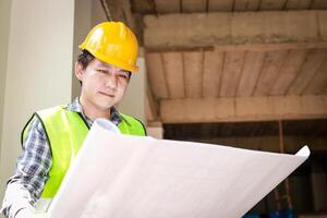 building contractor Hold the building blueprint at the job site to verify the correctness of the construction. building construction concept. copy space photo