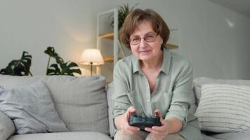 frente ver de mayor mujer jugando juego y utilizando palanca de mando video