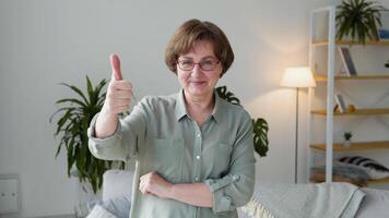 mooi oud dame op zoek in camera staand in de leven kamer van haar huis video