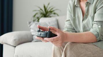 lado Visão do Senior mulher jogando jogos e usando controle de video game