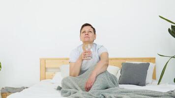 sonriente hermosa mayor adulto mujer bebidas agua sentado en cama video