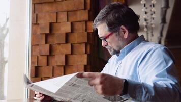 Senior man spending time in cafe reading newspaper video