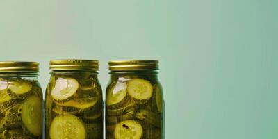 Homemade canned vegetables in glass jars. Pickled cucumbers on a plain background with copy space photo