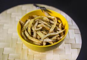 frito largo francés frijoles en amarillo cerámica taza. foto