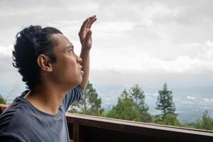 hombre sentado cerca cerca y mirando el paisaje montaña. el foto es adecuado a utilizar para calma disfruté actividad, ocio actividad y parque antecedentes.