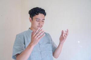 Moslem Asian man prayer gesture when Ramadan celebration. The photo is suitable to use for Ramadhan poster and Muslim content media.