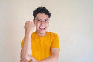 joven hombre vestir amarillo camiseta con fuerte actitud expresión gesto. el foto es adecuado a utilizar para hombre expresión publicidad y Moda vida estilo.