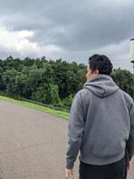 Man walking on the park when day time. The photo is suitable to use for calm enjoyed activity, leisure activity and park background.